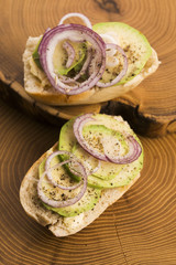 Sandwich with avocado, red onion, salt and herbs