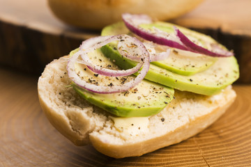 Sandwich with avocado, red onion, salt and herbs