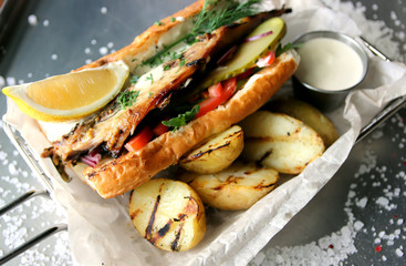 Baked potatoes, hamburger with fish and vegetables and sauce..