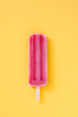 Strawberry popsicle on yellow background
