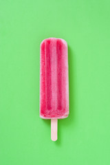 Strawberry popsicle on green background
