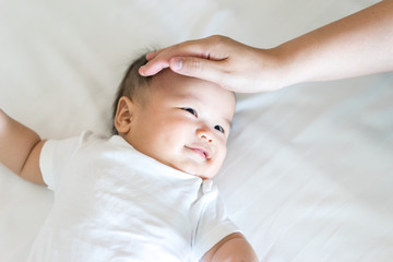 Portrait of a newborn Asian baby on the bed