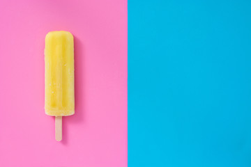 Lemon popsicle on pink and blue background
