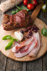 Smoked bacon with bread, mozzarella, olives and basil