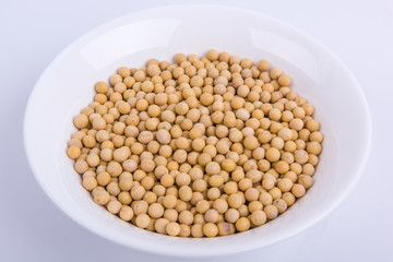 Soybeans in a white bowl isolated on white background.