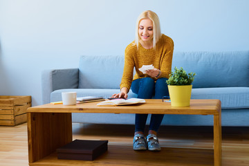 Cheerful woman counting home finance on calculator
