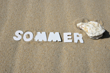 Sommer Buchstabend im Sand am Strand
