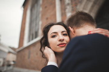 Gorgeous wedding couple, bride, groom posing near old gate building