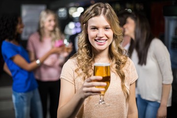 Smiling girl having a beer with her friends