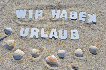 Wir haben Urlaub Text im Sand