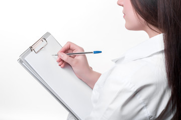 Detail of female doctor writing on clipboard