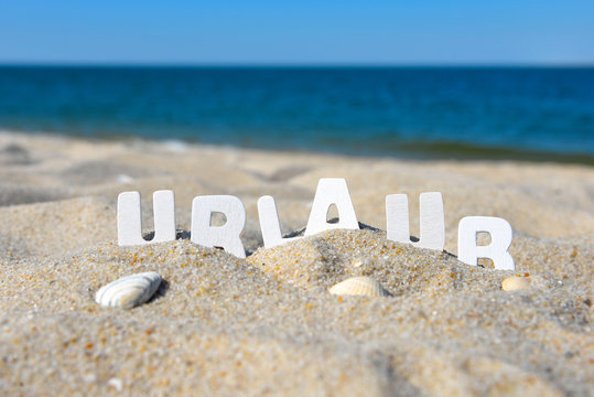 Urlaub Strand Buchstabend im Sand