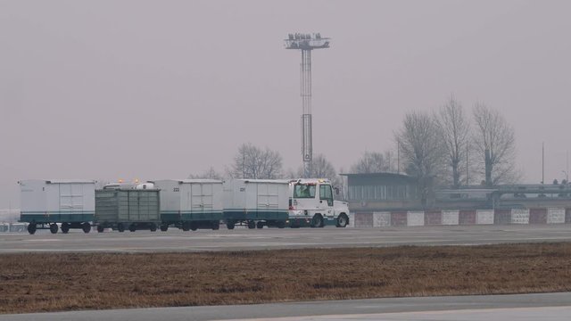A luggage tractor with passenger baggage in fog