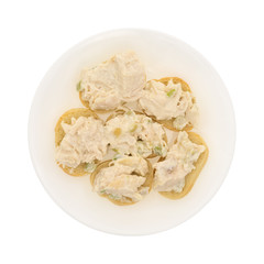 Chicken salad on a small pieces of French bread arranged on a plate isolated on a white background