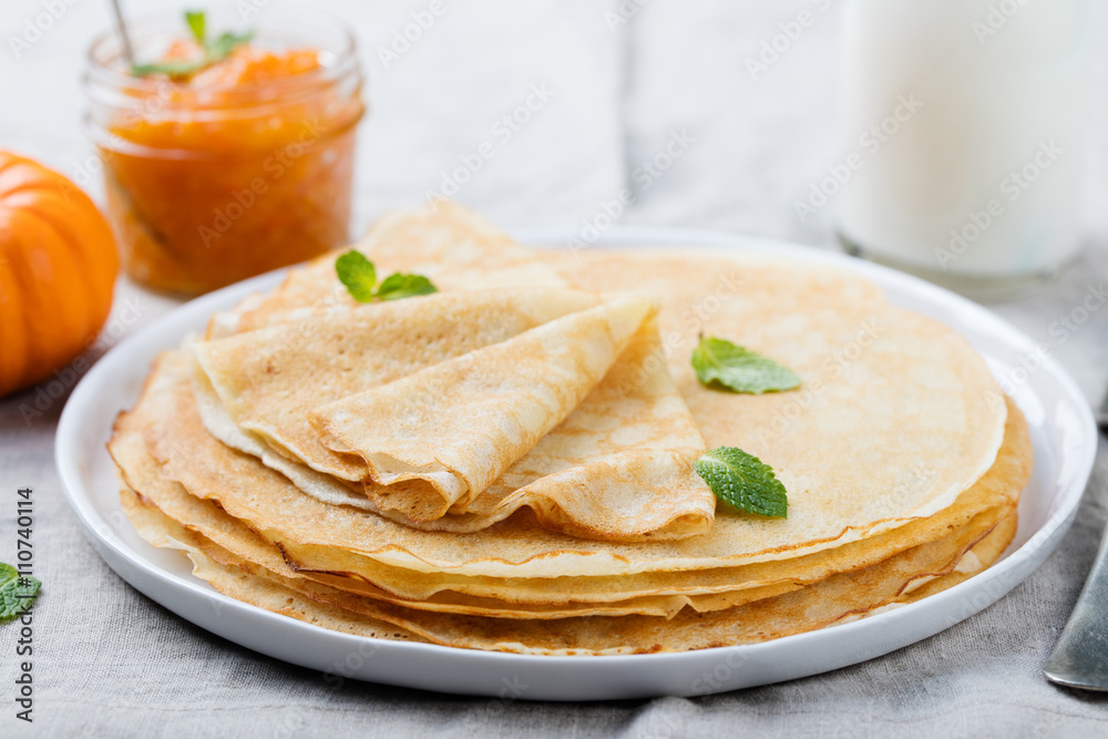 Wall mural thin crepes or pancakes with butter, honey and sour cream on a rustic textile background