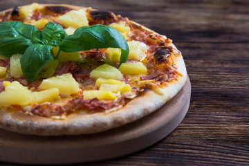 Hawaiian pizza on a wooden table