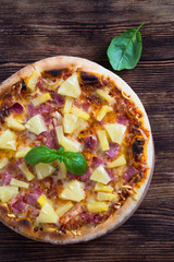 Hawaiian pizza on a wooden table
