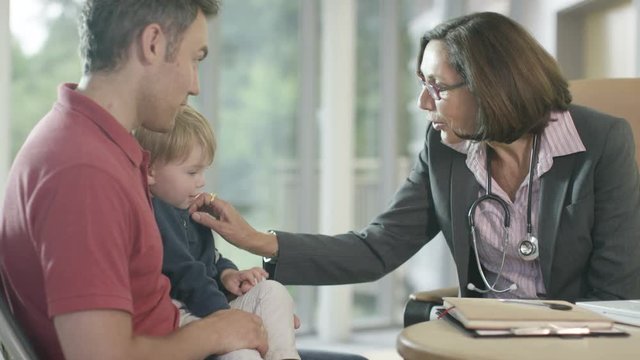  Friendly doctor talking to parent and child patient in office