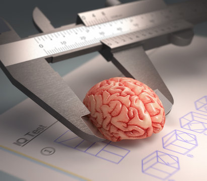 Caliper ruler measuring a human brain. Over the table a IQ Test in a concept of the human intelligence.