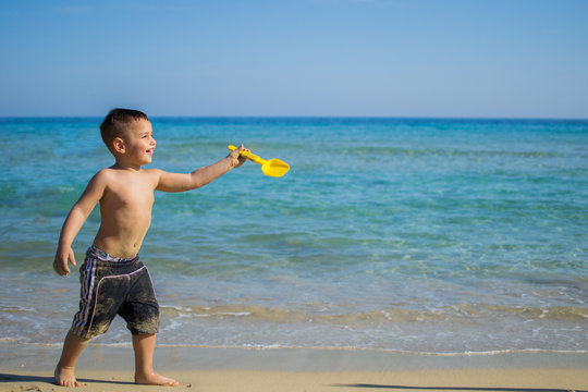 Bambino gioca in spiaggia con la paletta