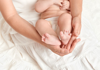 Fototapeta na wymiar baby feet in mother hand, health care concept, body and skin