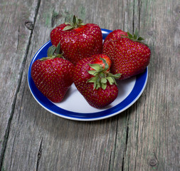 our big strawberries on a saucer, on a wooden table
