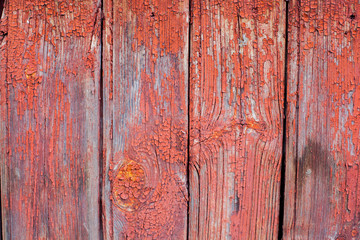 Old wooden boards. Cracked red paint.