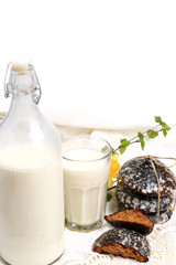 glass of milk and sweet cakes with ginger and vanilla rustic home cooking white background