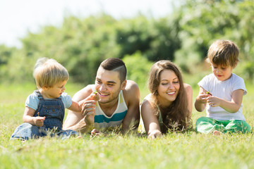 Fototapeta premium Czteroosobowa rodzina w słonecznym parku