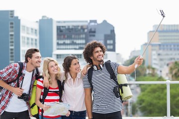 Group of friends taking selfie with selfie stick