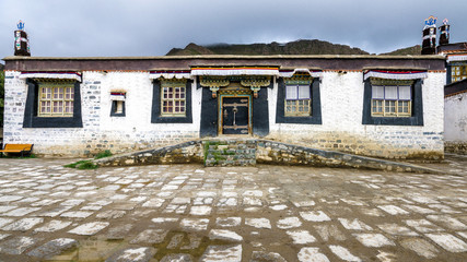 Традиционный тибетский дом с черными окнами и украшенными воротами