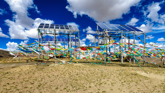 Solar panels decorated with ritual corol flags in the tibetan mountains in China