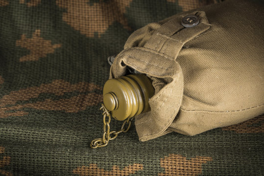Closed soldier flask on camouflage textile