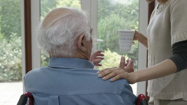  Caring home support nurse taking care of elderly man in his home