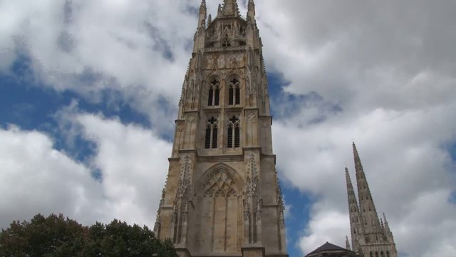 Tilt shot up the Pey Berland Tower in Bordeaux Cathedral. Clouds flot past in the background