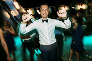 Groom in the bow-tie dances on the wedding