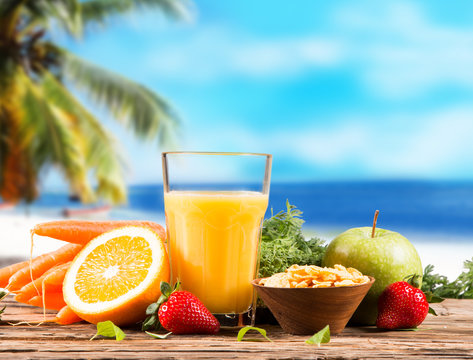 Fresh juice orange on wood with tropical beach background