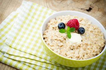 Oatmeal porridge in bowl with berries raspberries and blackberri