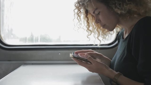 Frizzy woman using tablet PC in trip by train