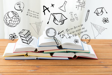close up of books on table over school doodles
