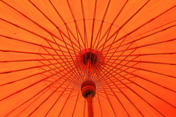 Red paper umbrella made from bamboo stalks.