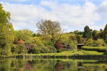 Fototapeta na wymiar Newstead Abbey Garden Lake and gardens behind. In Newstead, Nottinghamshire, England. on 16th May 2016.