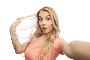 Obraz premium young woman taking selfie and making fish face
