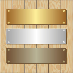 golden silver and bronze plaques on wooden background