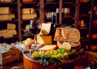 Cheese and wine on a dark table.