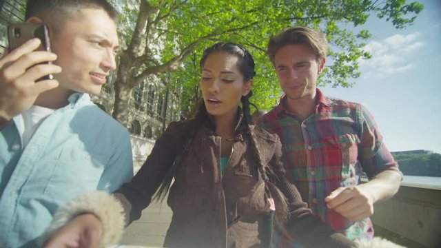  Casual group of friends looking at London map and trying to find their way around the city. Shot on RED Epic