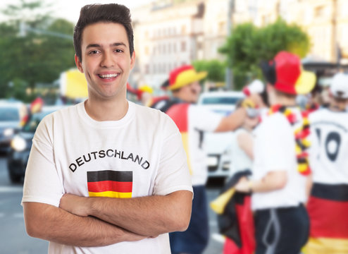 Lachender deutscher Fussball Fan mit dunklen Haaren beim Autocorso