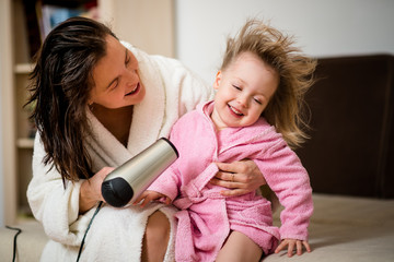 Mother drying hair of her daughter