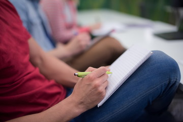male student taking notes in classroom