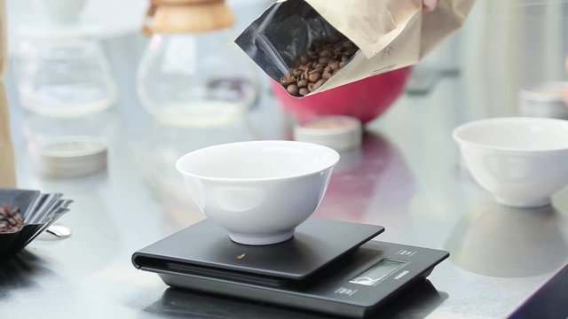 Coffee beans are weighed on kitchen electronic scales.